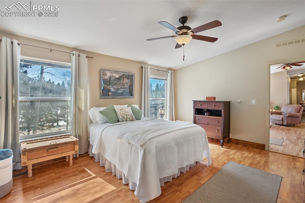 63 Bear Claw Trail Divide, CO 80814 - Photo 16 of 28 a bedroom with a large bed and a chandelier