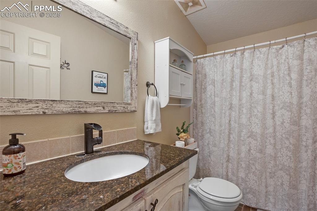 63 Bear Claw Trail Divide, CO 80814 - Photo 19 of 28 a bathroom with a granite countertop sink and a mirror