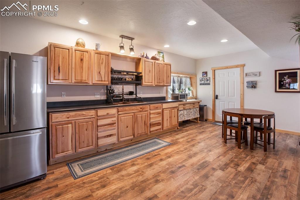 63 Bear Claw Trail Divide, CO 80814 - Photo 24 of 28 a kitchen with stainless steel appliances granite countertop a refrigerator a sink dishwasher a dining table and chairs with wooden floor
