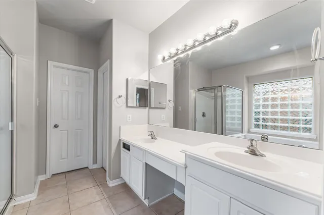 a spacious bathroom with a double vanity sink a mirror and a bathtub