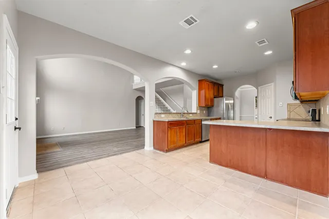 a view of kitchen with stainless steel appliances granite countertop a sink and a refrigerator