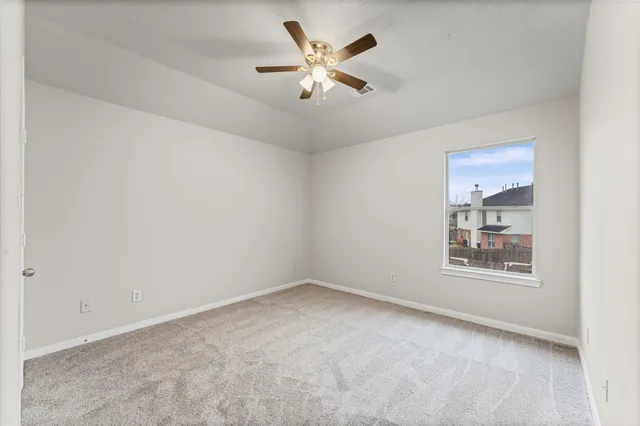 an empty room with cabinet and a ceiling fan