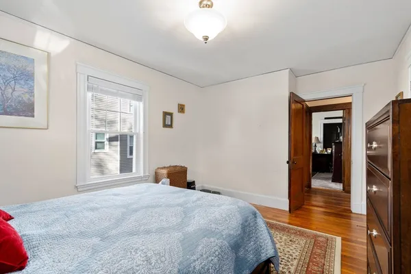 a bedroom with bed and wooden floor