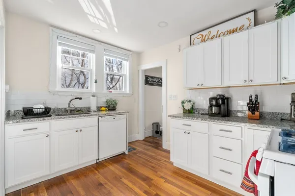 a kitchen with granite countertop white cabinets and white appliances