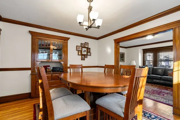 a dining room with furniture a chandelier and wooden floor