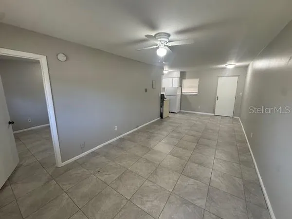 an empty room with fan and entrance