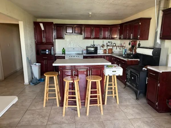 a kitchen with granite countertop wooden cabinets and dining table chairs