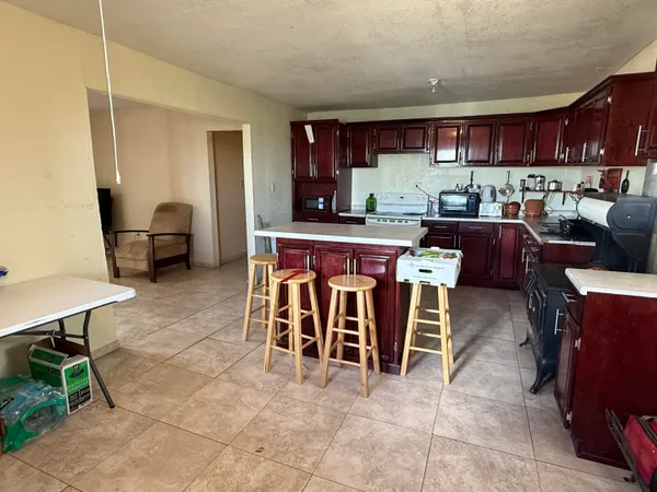 a living room with furniture a wooden floor and a kitchen view
