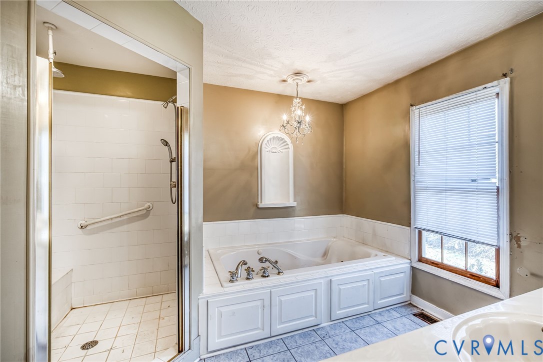 8910 Tunstall Road New Kent, VA 23124 - Photo 18 of 45 Bathroom featuring a stall shower, a chandelier, a