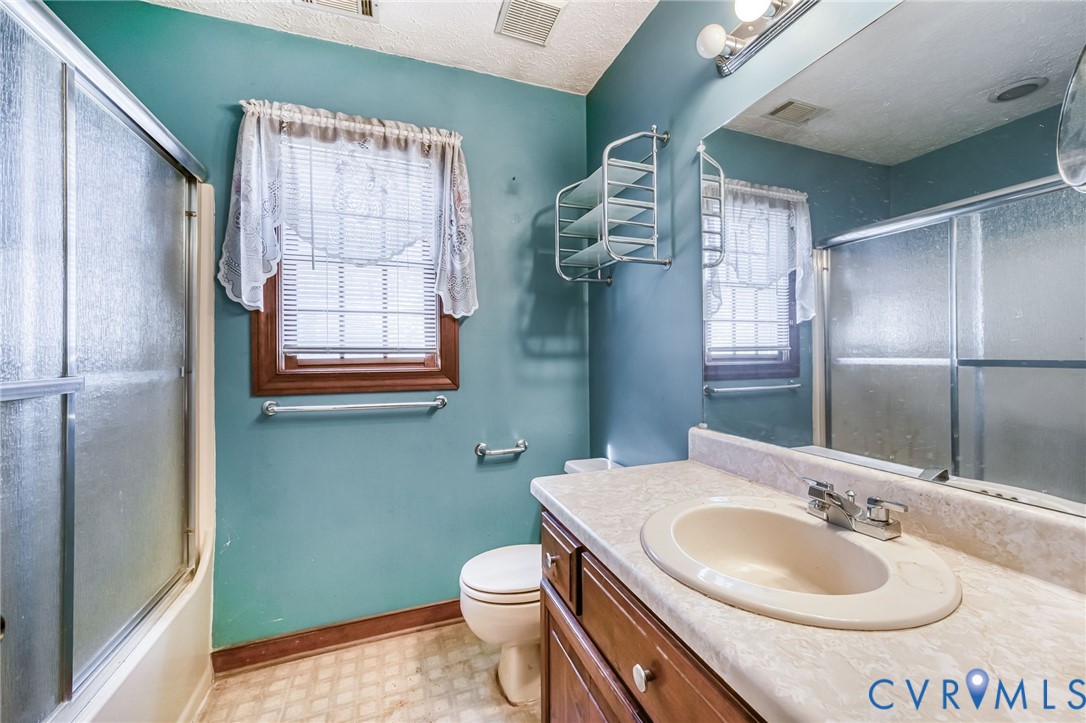 8910 Tunstall Road New Kent, VA 23124 - Photo 34 of 45 Bathroom with light floors, vanity, a textured cei