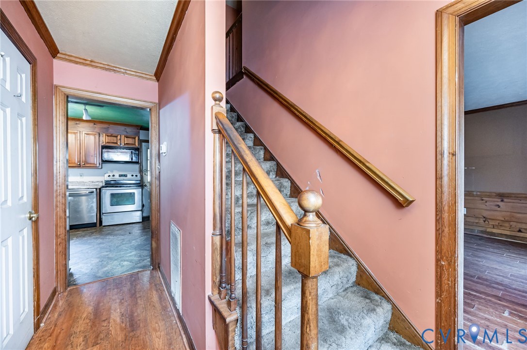 8910 Tunstall Road New Kent, VA 23124 - Photo 7 of 45 Stairway with crown molding and wood finished floo