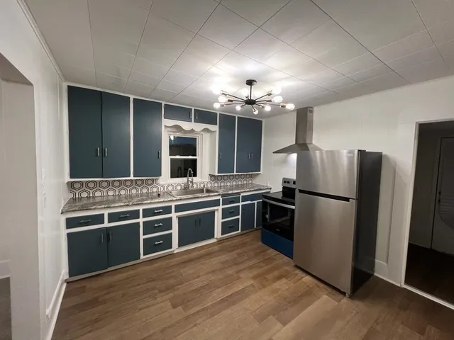 a kitchen with stainless steel appliances kitchen island granite countertop a stove and a refrigerator