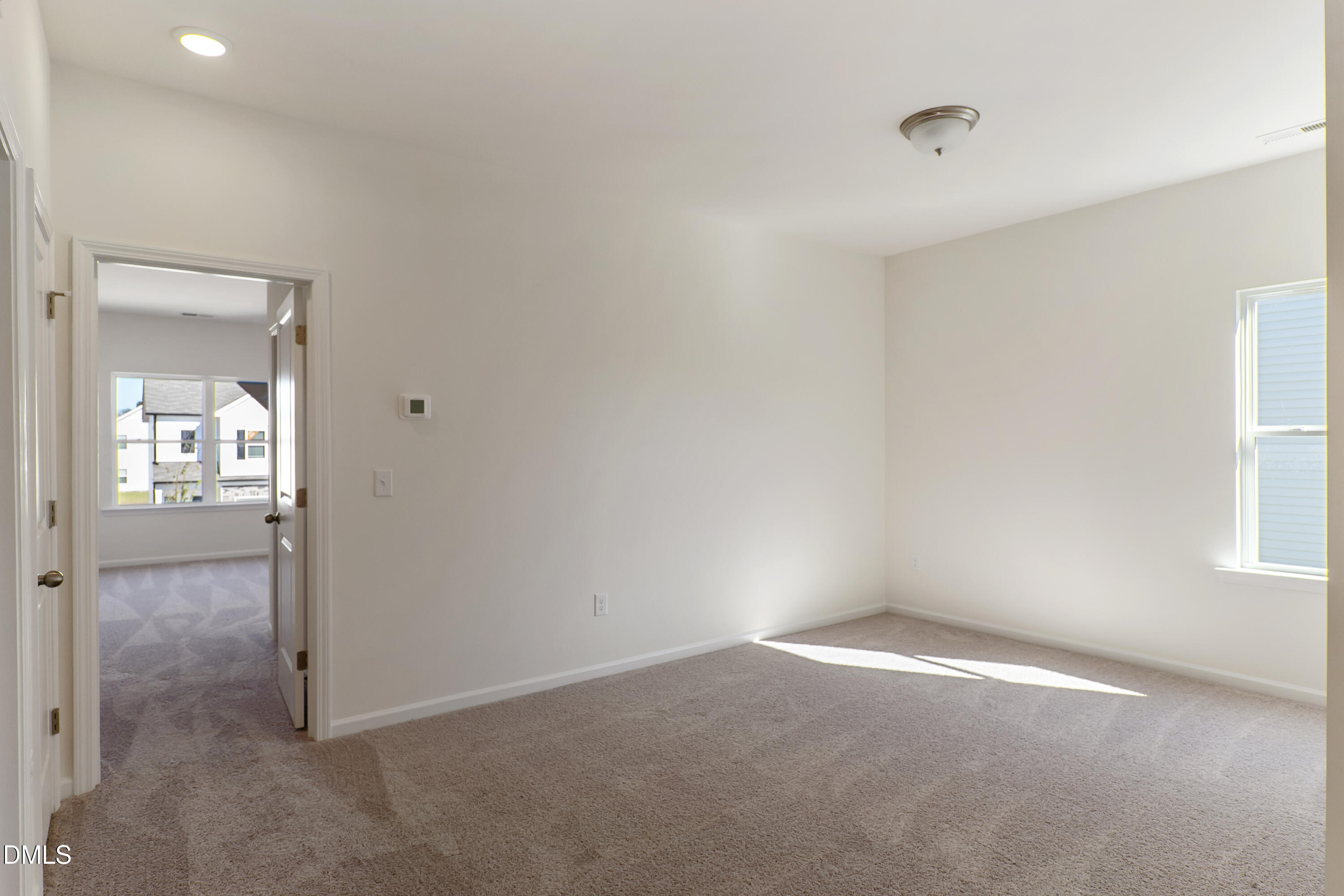 173 Courtside Drive Dunn, NC 28334 - Photo 9 of 24 an empty room with windows and a kitchen view