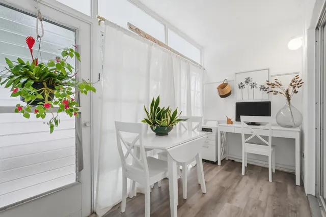 a dining room with furniture and a potted plant
