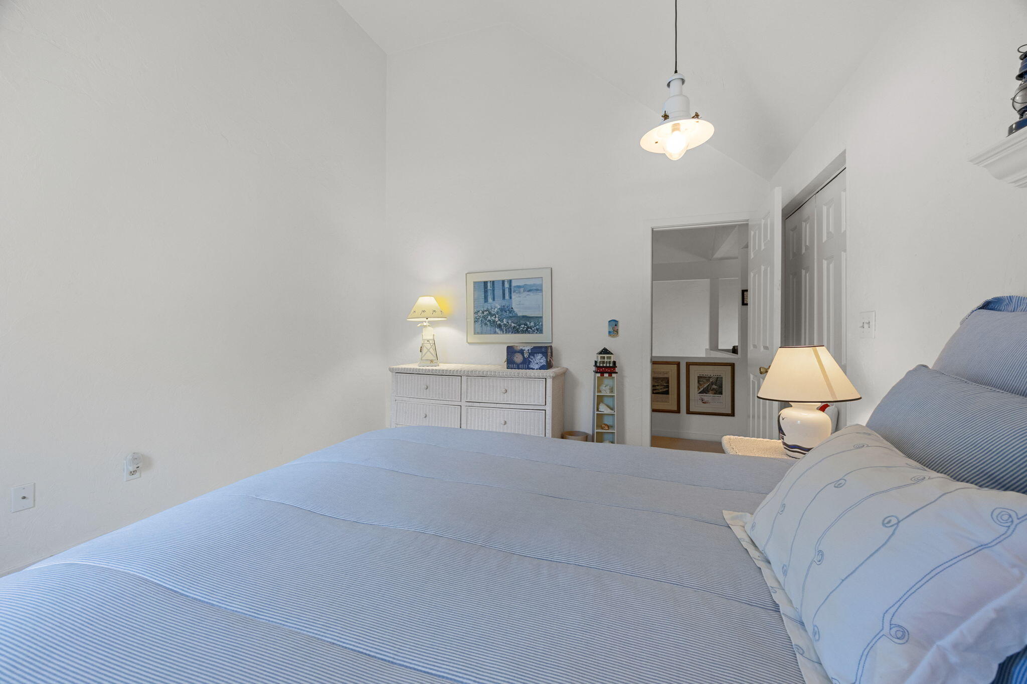 49 Shellback Way, Unit G Mashpee, MA 02649 - Photo 30 of 48 a large bedroom with a bed and a chandelier