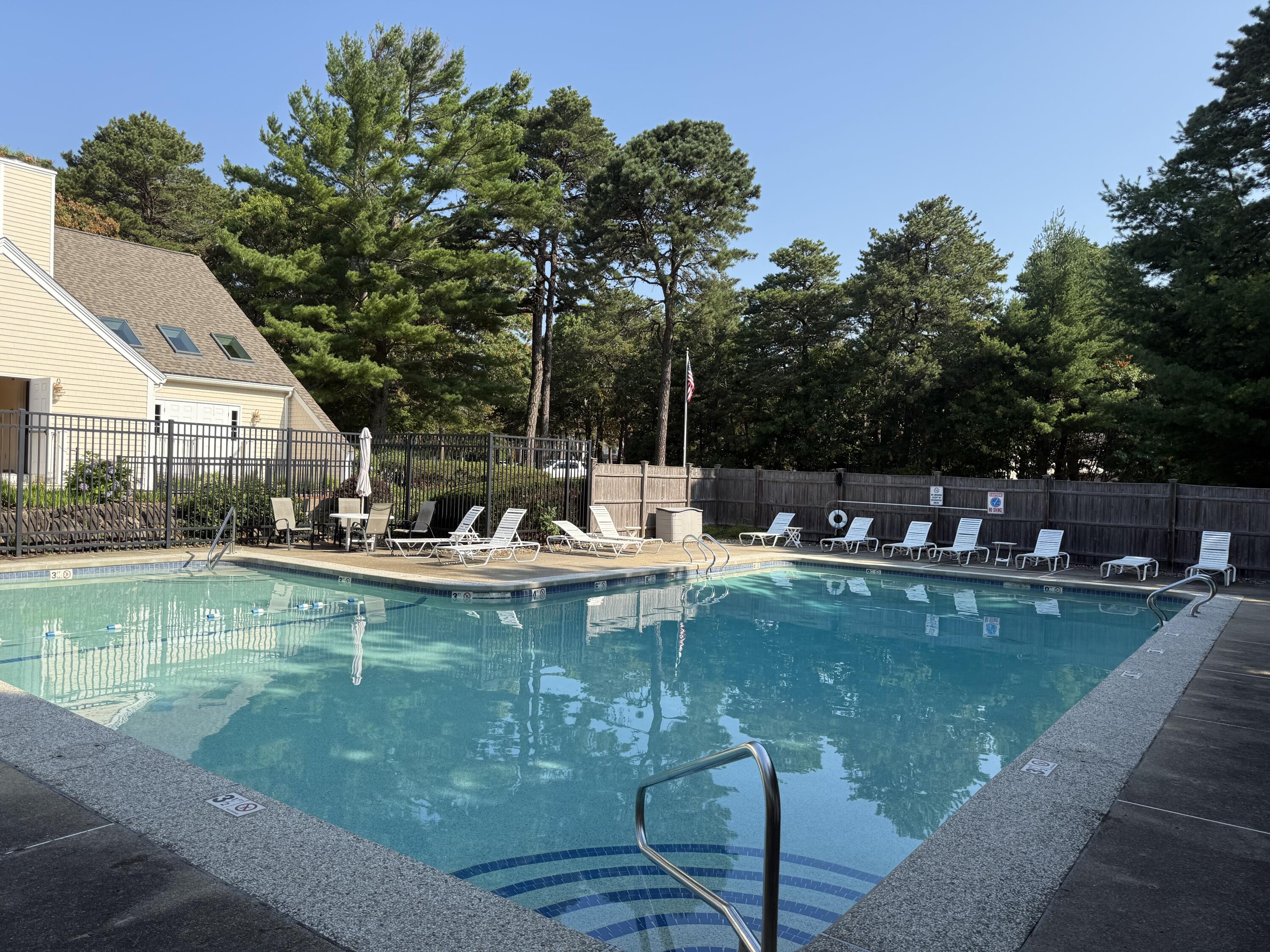 49 Shellback Way, Unit G Mashpee, MA 02649 - Photo 39 of 48 a view of a swimming pool with a table and chairs in patio