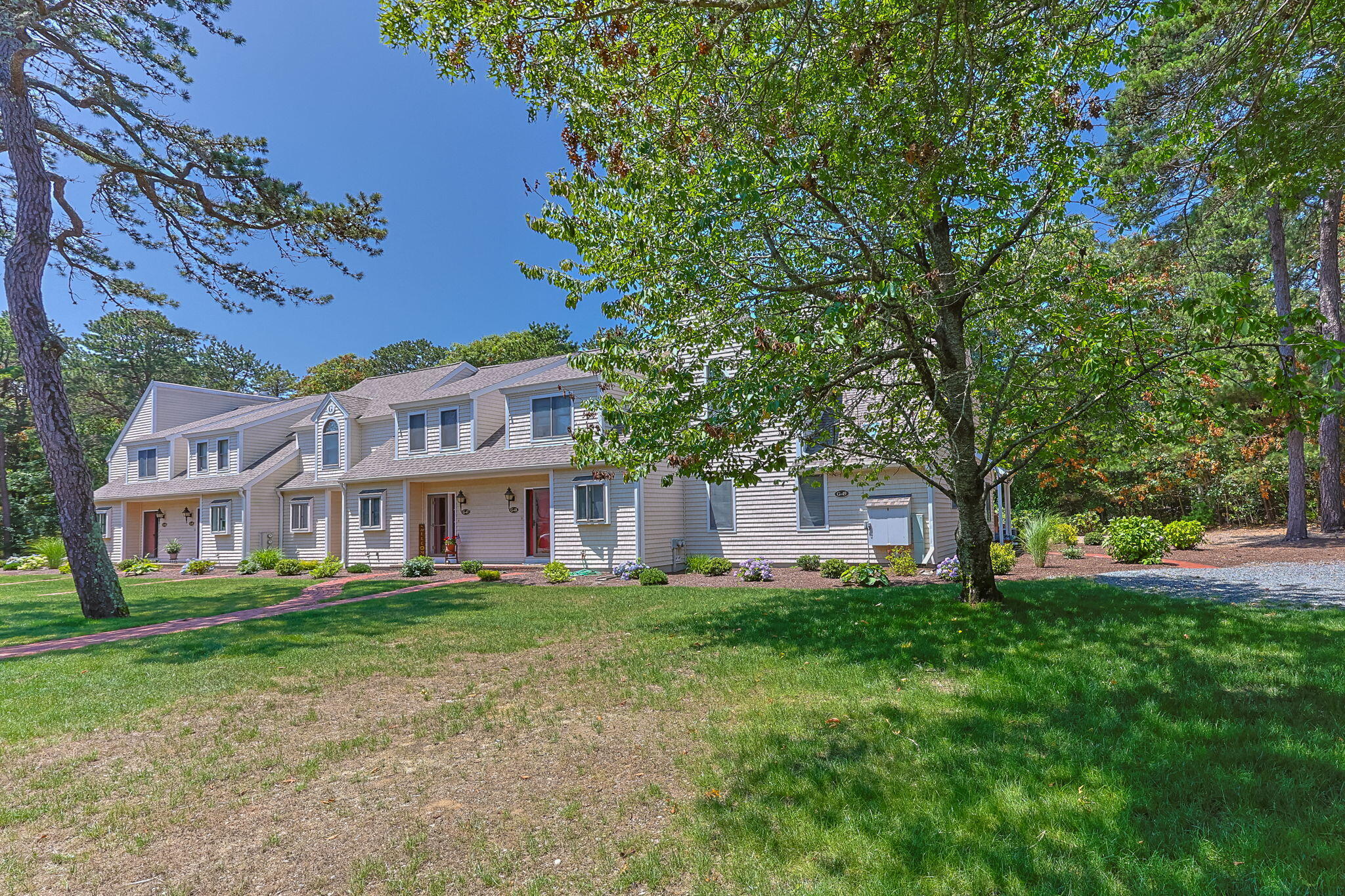49 Shellback Way, Unit G Mashpee, MA 02649 - Photo 4 of 48 a front view of a building with a garden