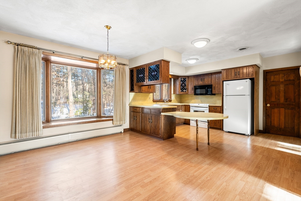 26 Nottingham Drive Raynham, MA 02767 - Photo 12 of 42 a kitchen with stainless steel appliances a stove a refrigerator a sink a oven with a dining table and chairs