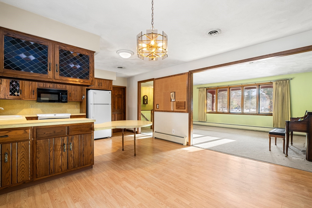 26 Nottingham Drive Raynham, MA 02767 - Photo 13 of 42 a living room with stainless steel appliances granite countertop furniture a fireplace a rug and a large window