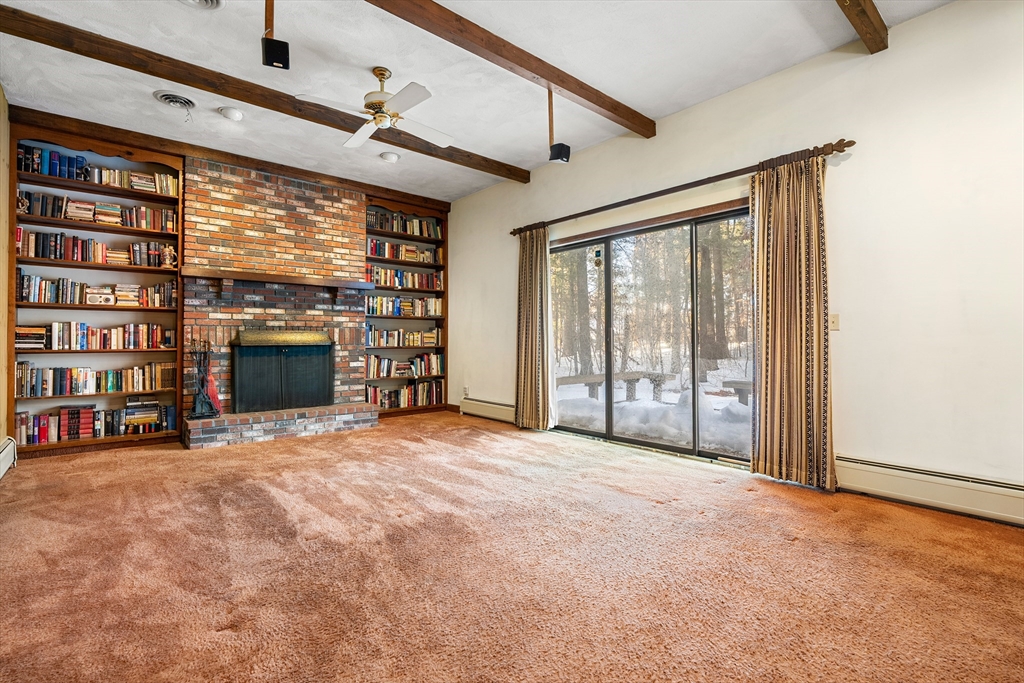 26 Nottingham Drive Raynham, MA 02767 - Photo 16 of 42 a view of an empty room with a fireplace and a window