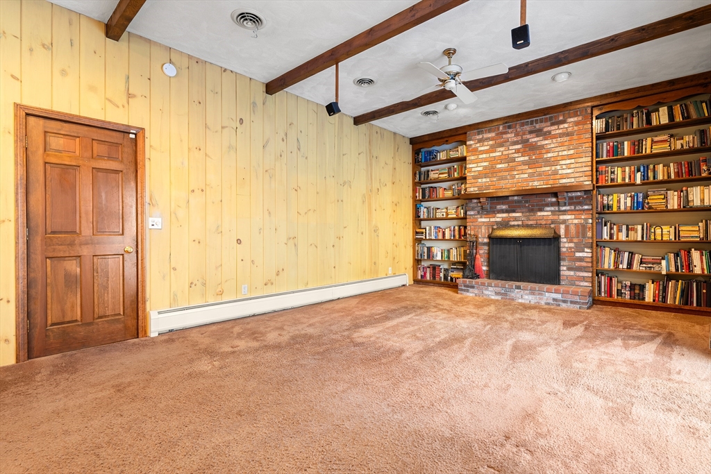 26 Nottingham Drive Raynham, MA 02767 - Photo 17 of 42 a view of an empty room with a fireplace and a window