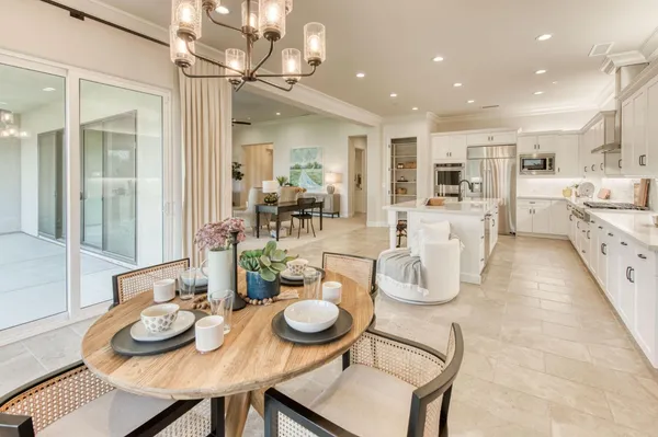 a dining room with furniture a chandelier and wooden floor