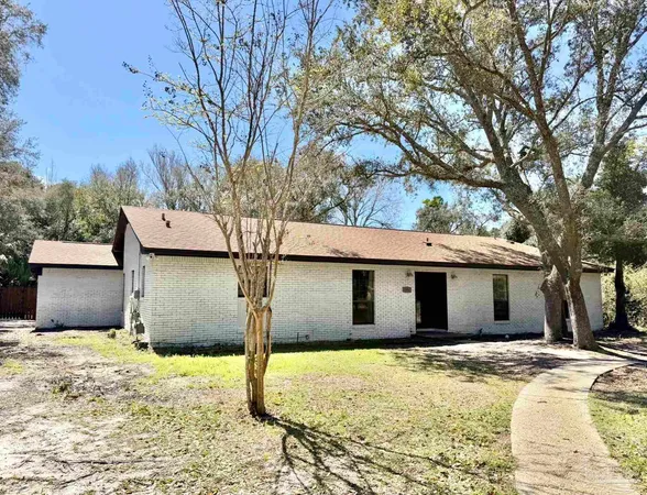 a backyard of a house with large trees and outdoor space