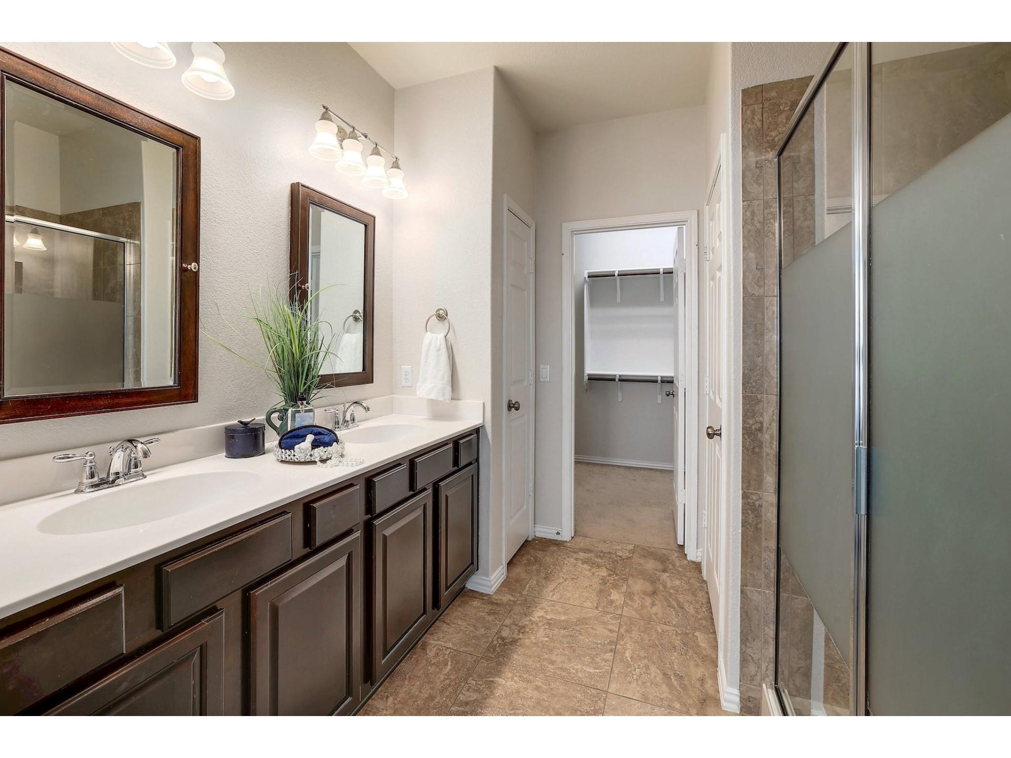 16021 Travesia Way Austin, TX 78728 - Photo 16 of 27 a bathroom with a double vanity sink and mirror