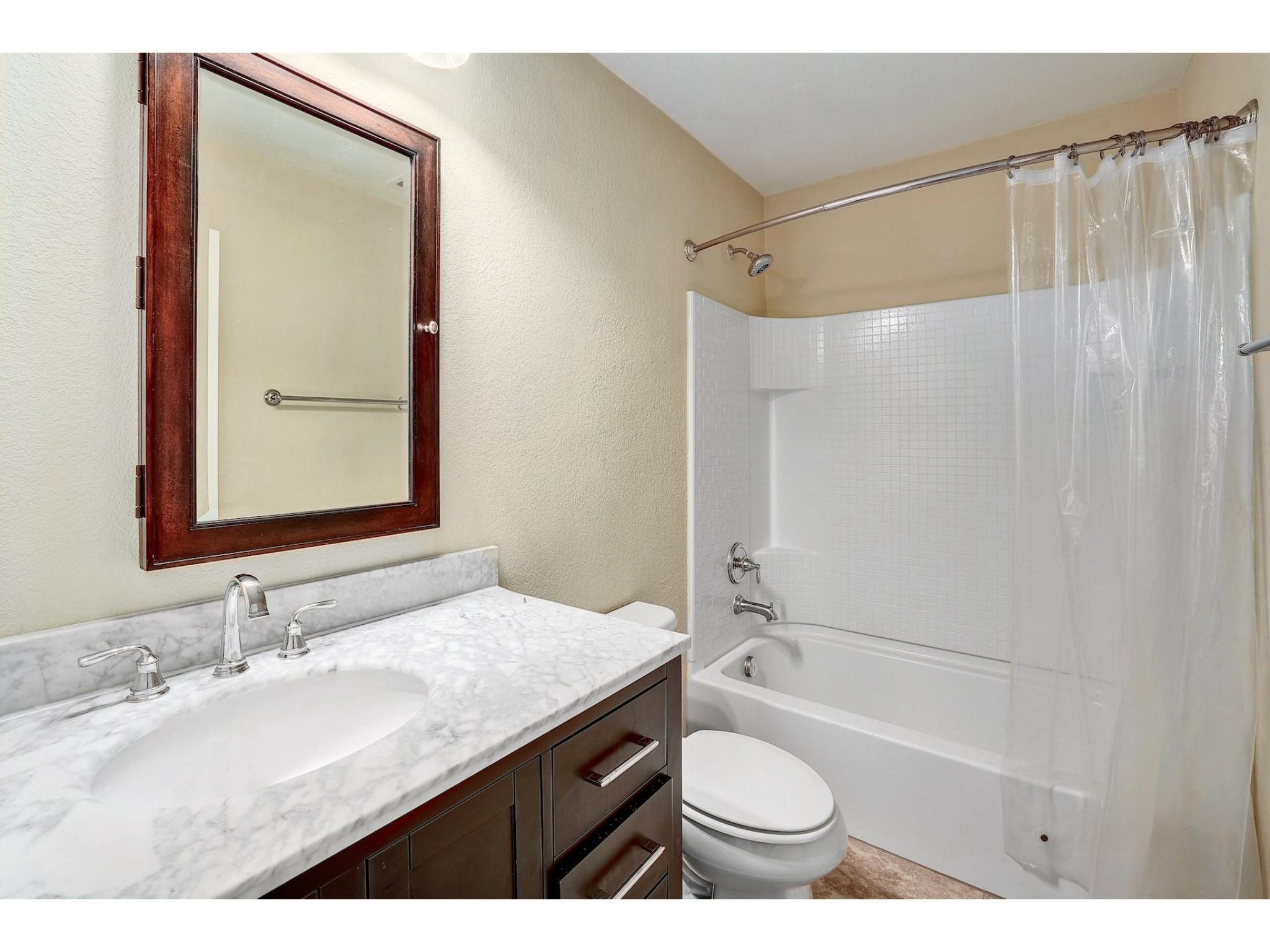 16021 Travesia Way Austin, TX 78728 - Photo 21 of 27 a bathroom with a granite countertop sink toilet and shower