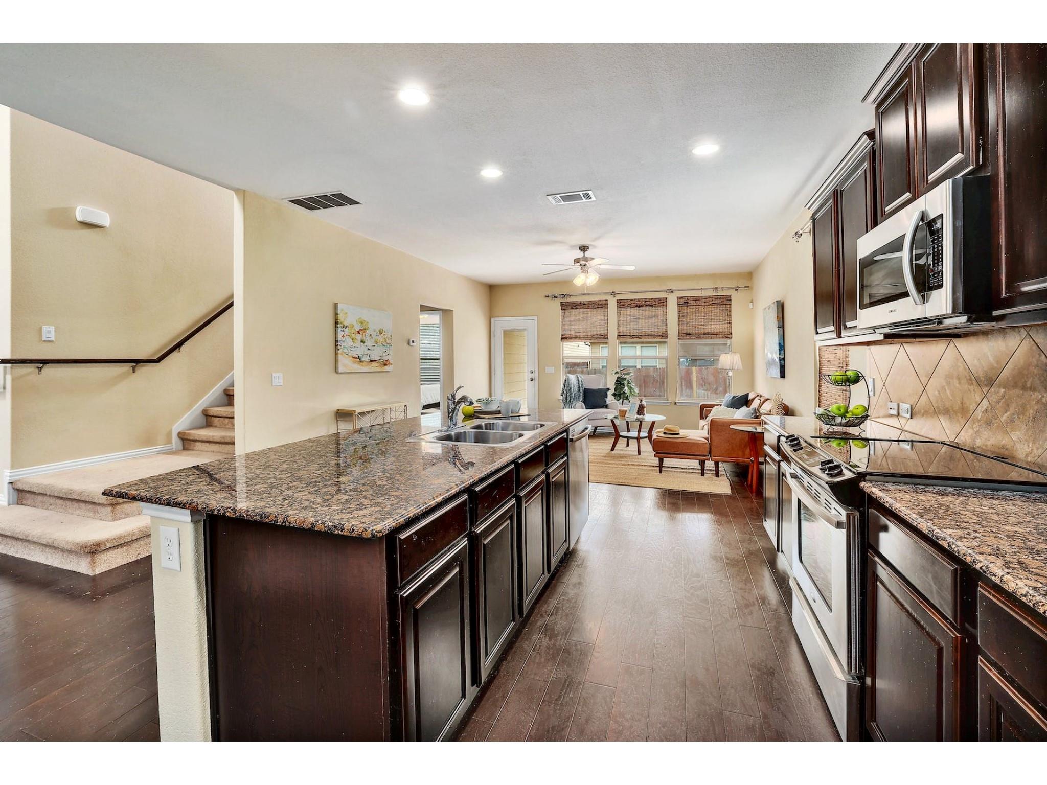 16021 Travesia Way Austin, TX 78728 - Photo 7 of 27 a kitchen with stainless steel appliances granite countertop a sink stove and oven