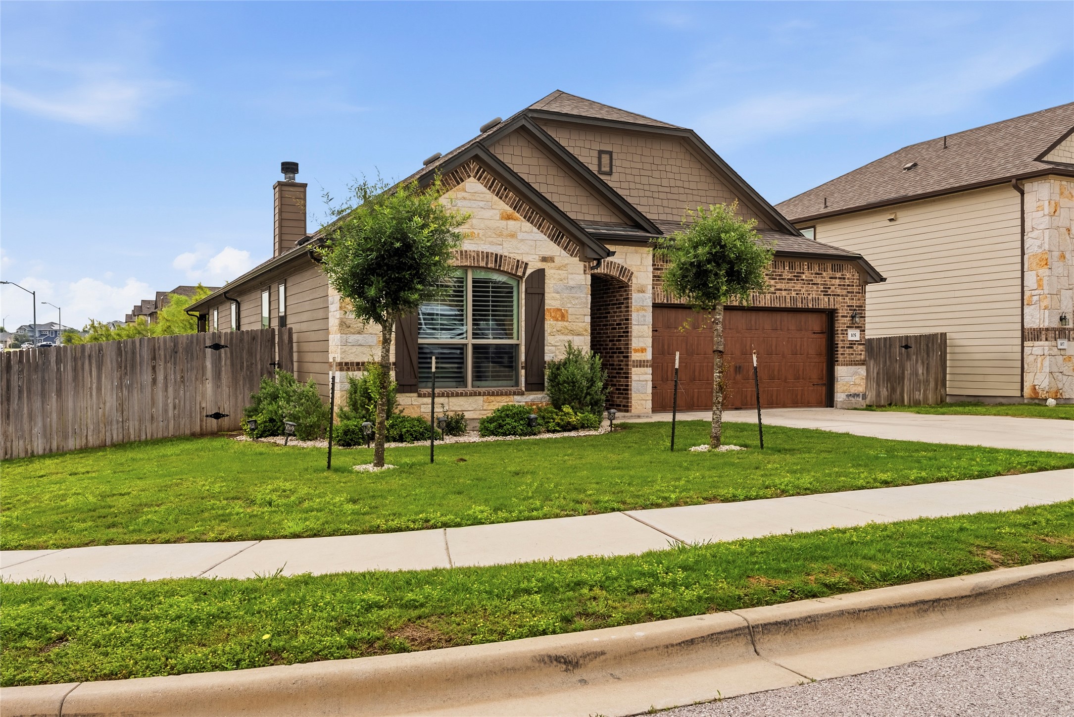 105 West Point Way Elgin, TX 78621 - Photo 2 of 27 Stone and brick exterior with wood-finish garage door