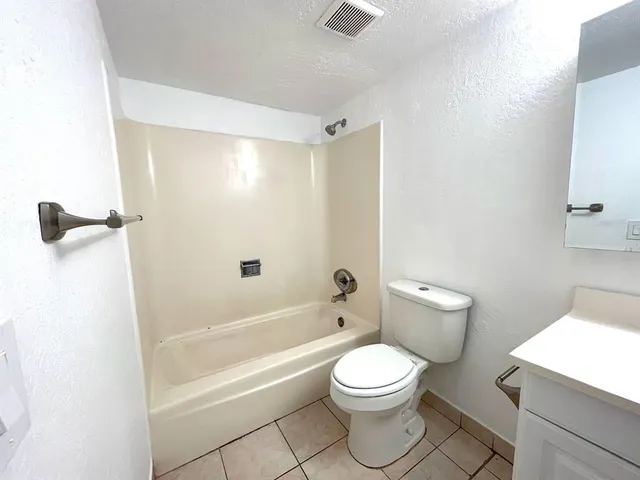 a white toilet sitting next to a bath tub