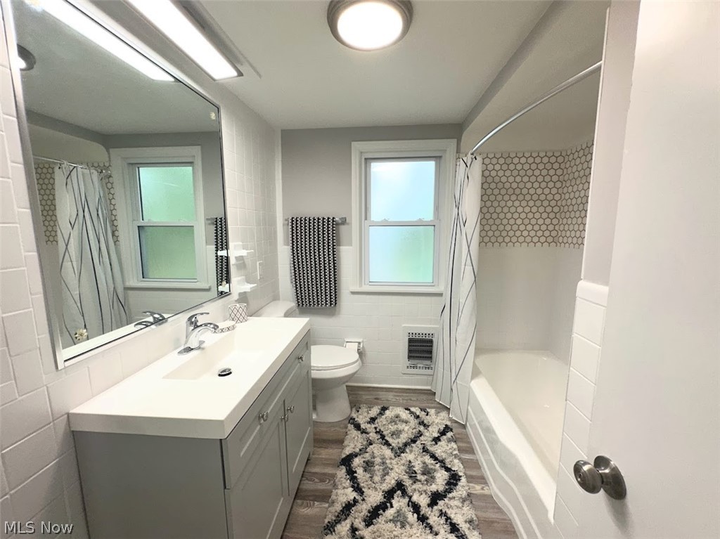 4227 Eastway Road South Euclid, OH 44121 - Photo 12 of 18 Full bathroom with toilet, vanity, tile walls, shower / bath combo, and hardwood / wood-style flooring