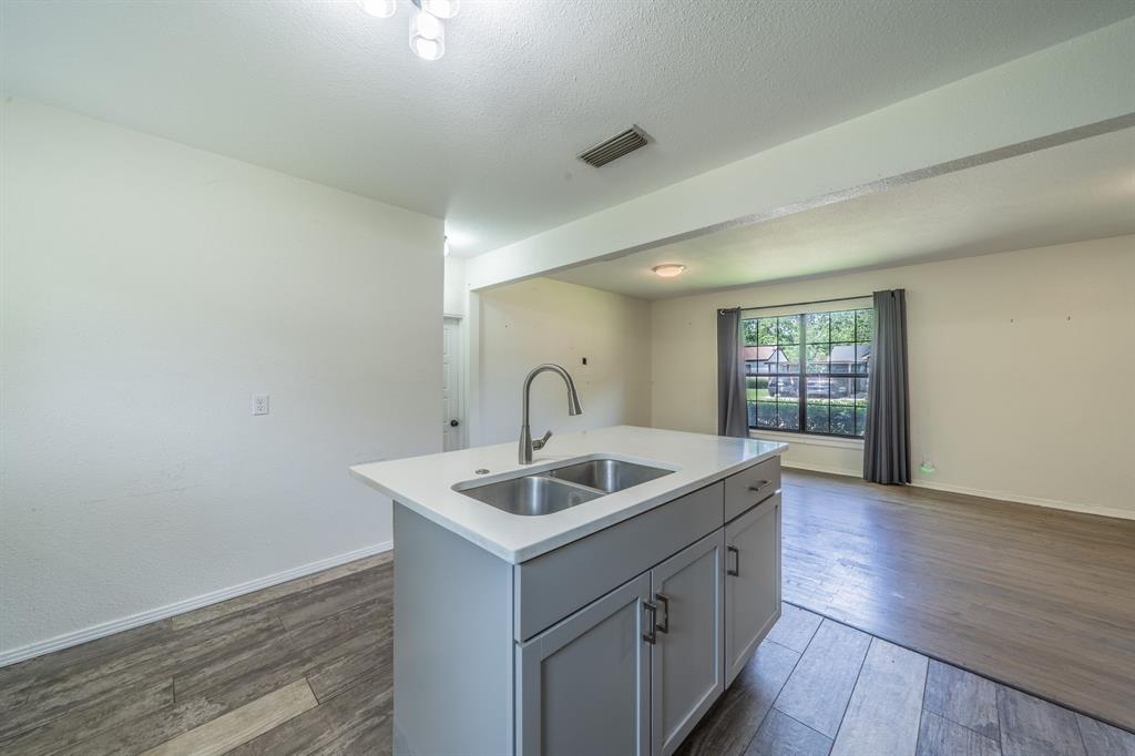 11528 Sinclair Avenue Dallas, TX 75218 - Photo 7 of 16 Kitchen island featuring a double basin stainless steel sink with a gooseneck faucet