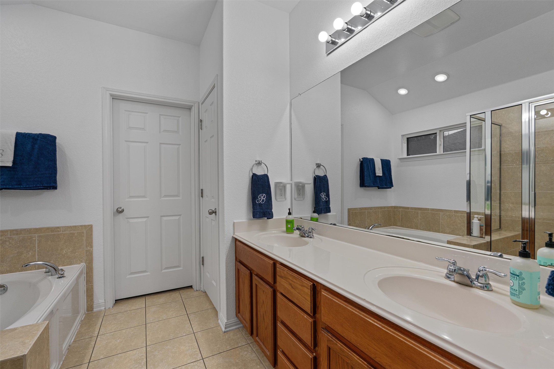 20513 Jackies Ranch Boulevard Pflugerville, TX 78660 - Photo 13 of 35 a spacious bathroom with a double vanity sink a mirror and a bathtub