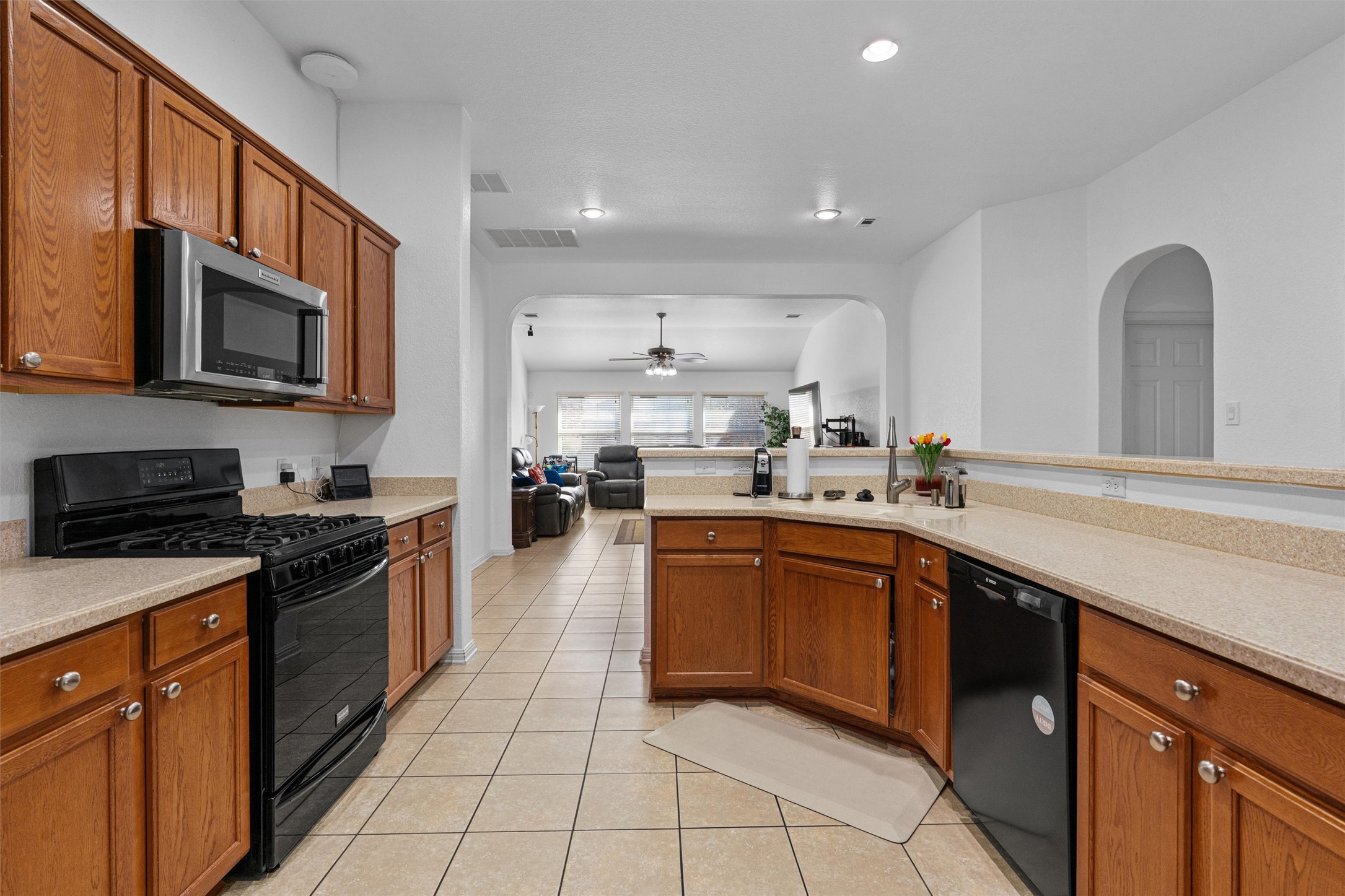 20513 Jackies Ranch Boulevard Pflugerville, TX 78660 - Photo 35 of 35 a large kitchen with stainless steel appliances granite countertop a stove top oven a sink dishwasher and wooden cabinets with a large window