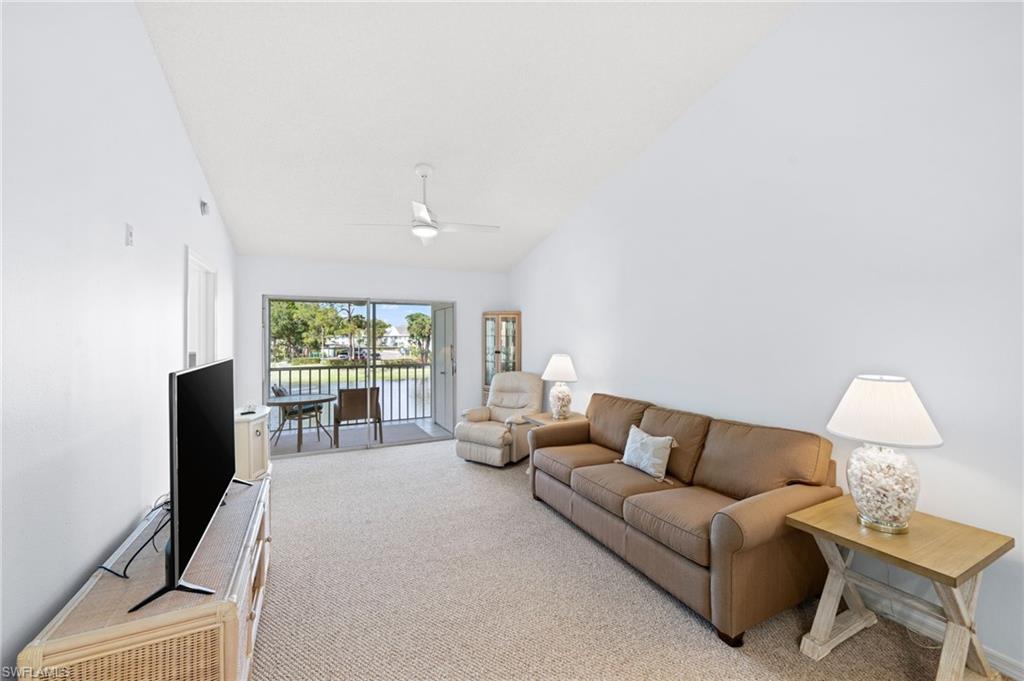 121 Wading Bird Circle, Unit B201 Naples, FL 34110 - Photo 12 of 33 a living room with furniture and a flat screen tv