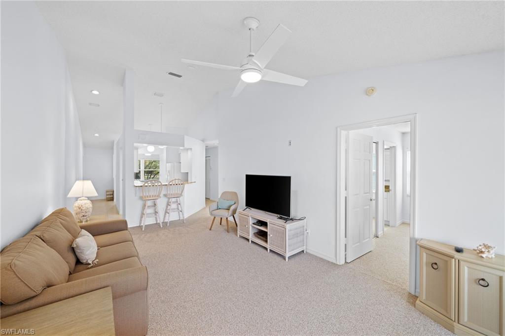 121 Wading Bird Circle, Unit B201 Naples, FL 34110 - Photo 15 of 33 a living room with furniture and a flat screen tv