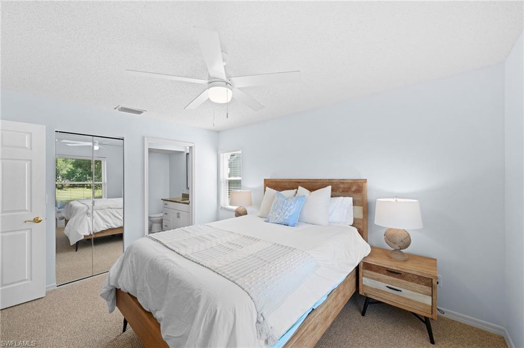 121 Wading Bird Circle, Unit B201 Naples, FL 34110 - Photo 19 of 33 a bedroom with a bed and a large window