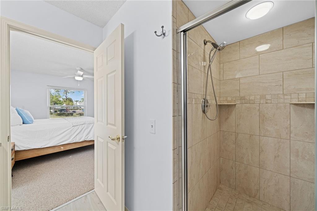 121 Wading Bird Circle, Unit B201 Naples, FL 34110 - Photo 22 of 33 a bathroom with a double vanity sink and shower