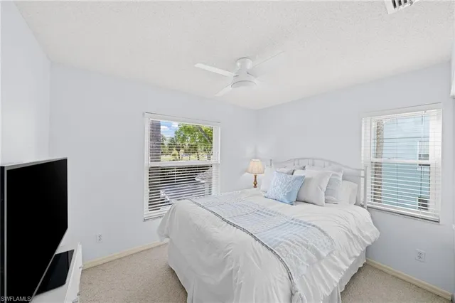 a bedroom with a bed and a flat tv screen on the dresser