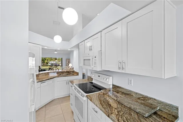 a kitchen with granite countertop a sink a stove and cabinets