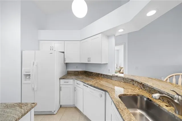 a kitchen with granite countertop a sink and a stove top oven
