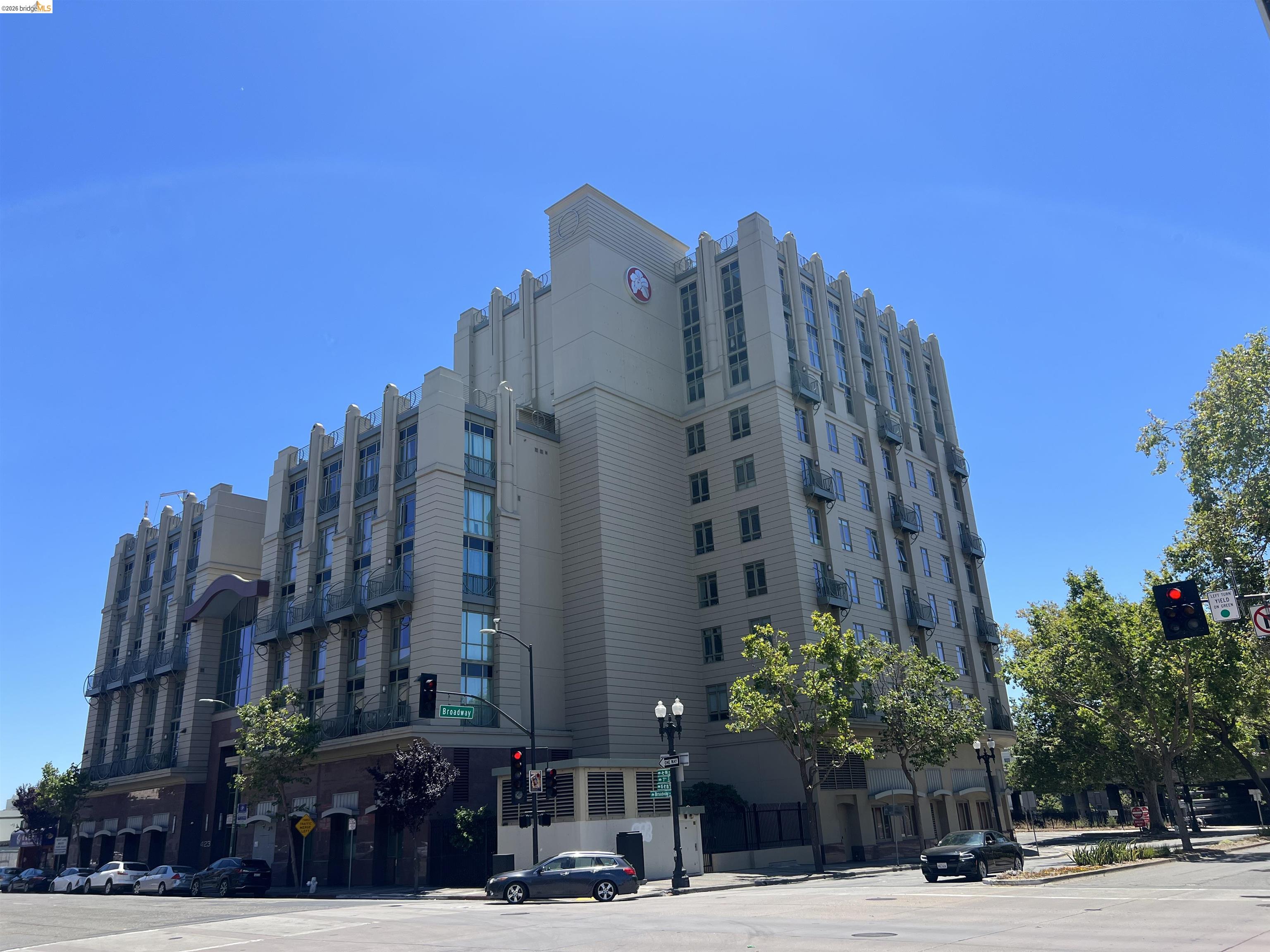 423 7th Street, Unit 313 Oakland, CA 94607 - Photo 1 of 11 Multi-story building featuring an Art Deco architectural style, vertical window banks, individual balconies, a light-colored facade, and a prominent corner location