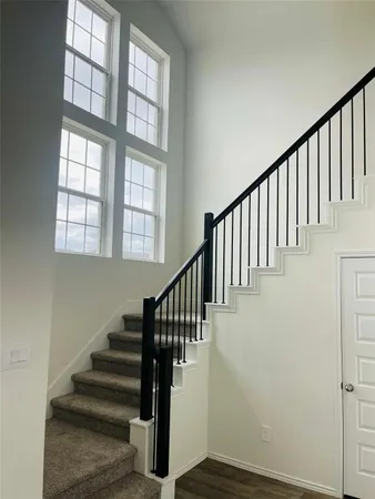 a view of staircase with lots of frames on wall and a window