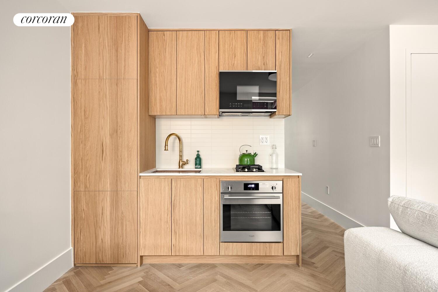 95 Monroe Street Brooklyn, NY 11216 - Photo 15 of 21 a kitchen with stainless steel appliances wooden cabinets and a stove top oven