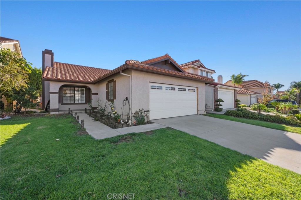 12152 Crystal Ridge Way Porter Ranch, CA 91326 - Photo 1 of 1 a front view of a house with a garden and yard