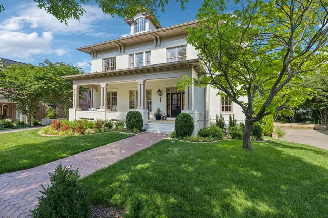 a large white kitchen with a large window a sink and stainless steel appliances
