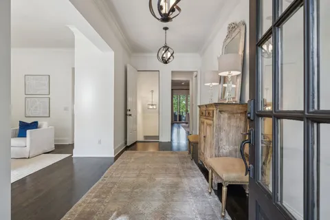 a living room with furniture kitchen view and a wooden floor