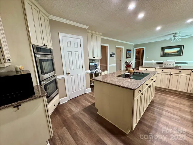 a kitchen with granite countertop a sink stove and refrigerator